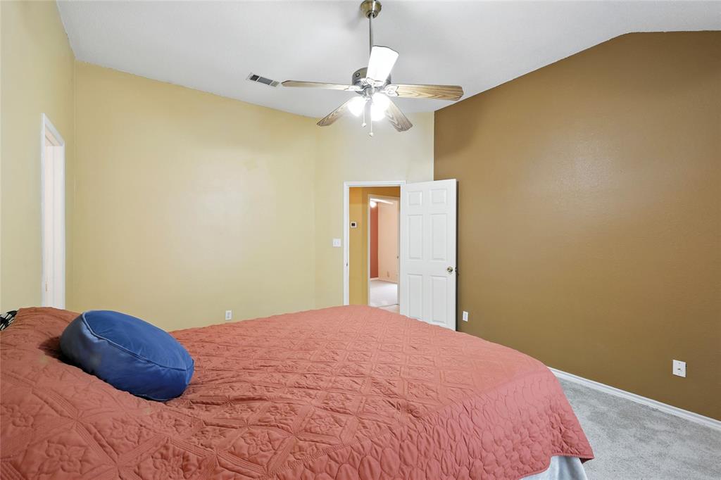 4609 Hunters Ridge Drive Sachse, TX 75048 - Photo 18 of 38 a bedroom with a bed and a chandelier