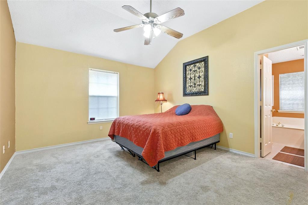 4609 Hunters Ridge Drive Sachse, TX 75048 - Photo 19 of 38 a spacious bedroom with a bed and a chandelier