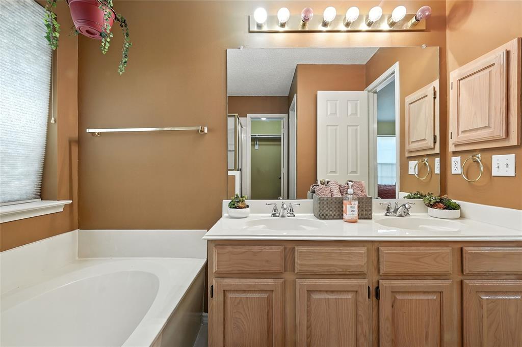 4609 Hunters Ridge Drive Sachse, TX 75048 - Photo 21 of 38 a bathroom with a granite countertop sink mirror and a bathtub