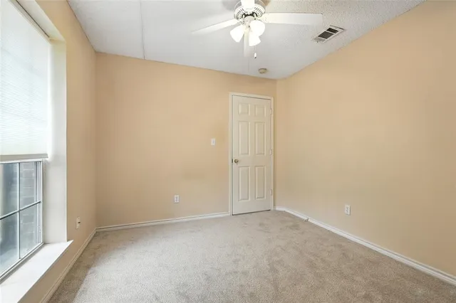an empty room with a chandelier fan