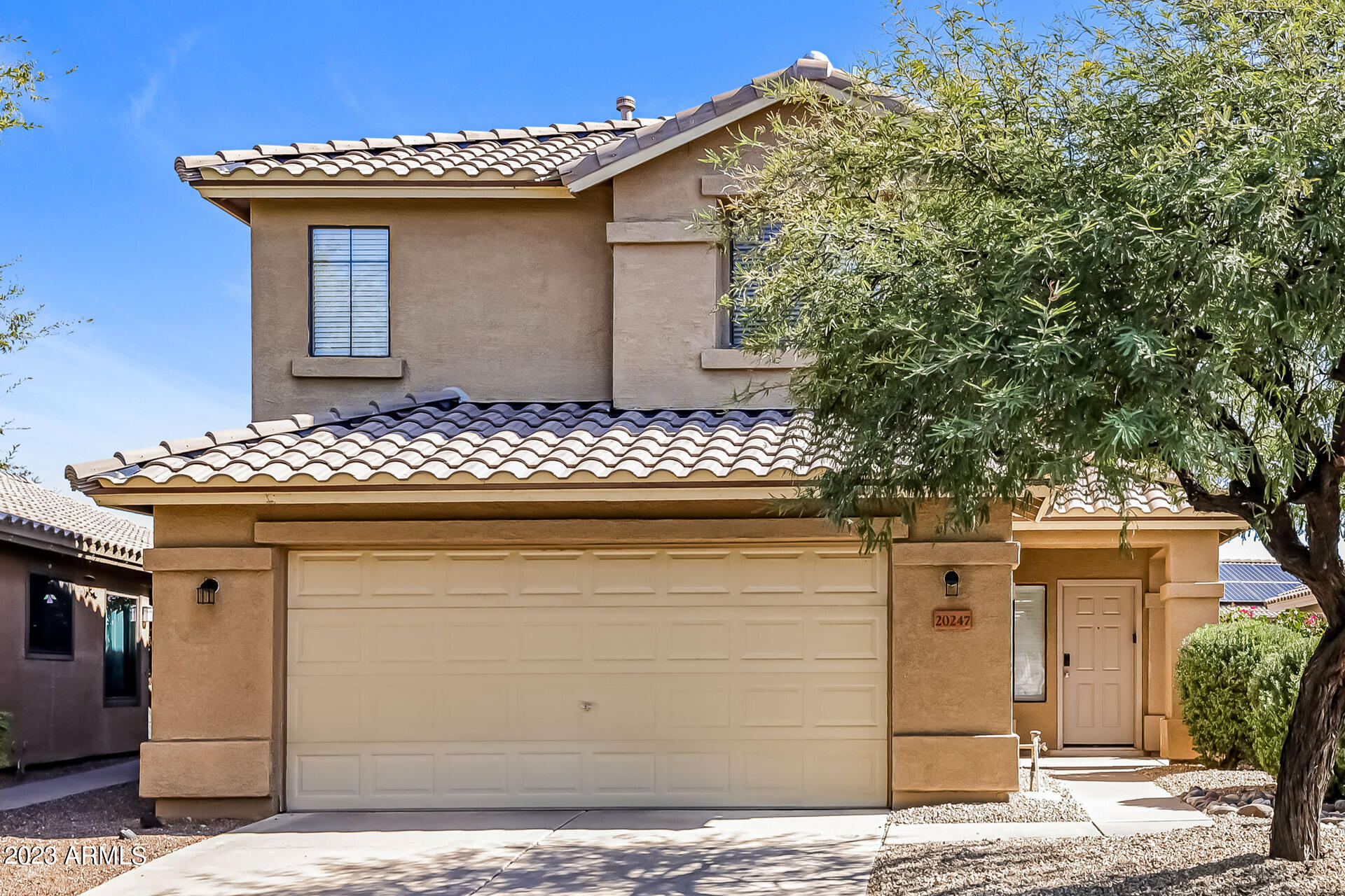 a front view of a house with plants