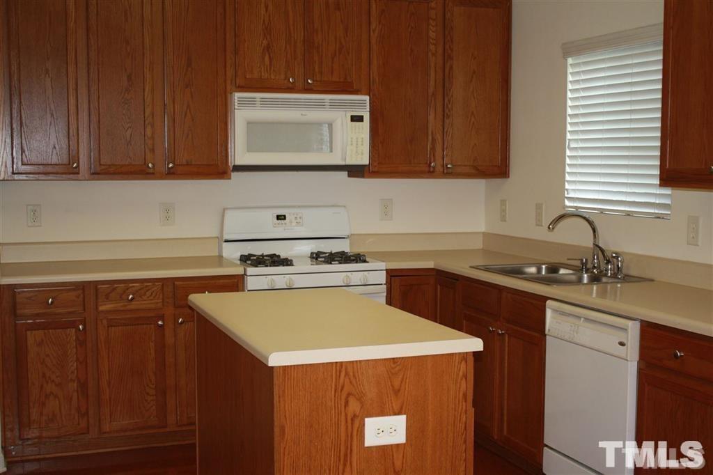 114 Graystar Road Apex, NC 27502 - Photo 3 of 8 enjoy this kitchen with hardwood floors, island, ample counter space, microwave & gas stove...