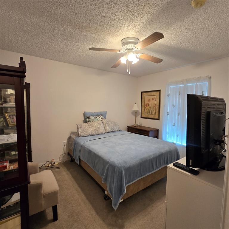 7280 Pinehurst Drive Spring Hill, FL 34606 - Photo 15 of 26 a bedroom with a bed and a flat tv screen on dresser