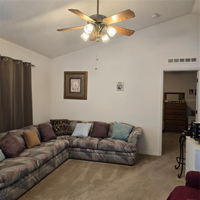 7280 Pinehurst Drive Spring Hill, FL 34606 - Photo 4 of 26 a living room with furniture and a ceiling fan