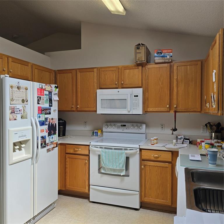 7280 Pinehurst Drive Spring Hill, FL 34606 - Photo 7 of 26 a kitchen with a sink stove and refrigerator