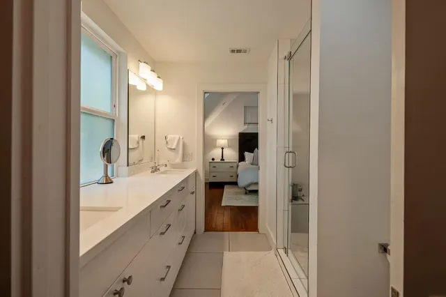 a en suite bathroom with a sink double vanity and a mirror