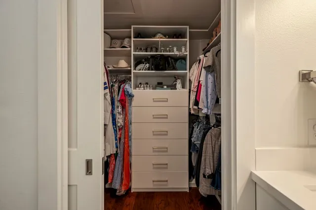 a view of walk in closet with clothes and shoes