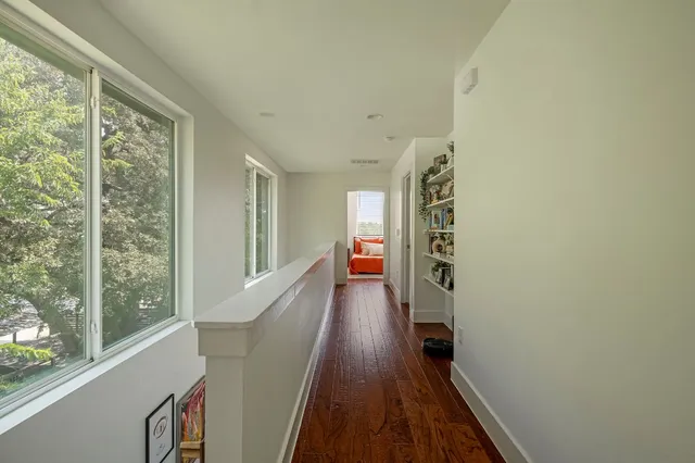 a view of hallway with stairs and wooden floor