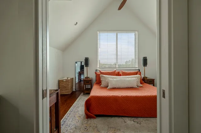 a bedroom with a bed and wooden floor