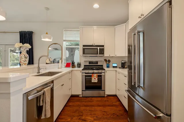 a kitchen with a sink stainless steel appliances and cabinets