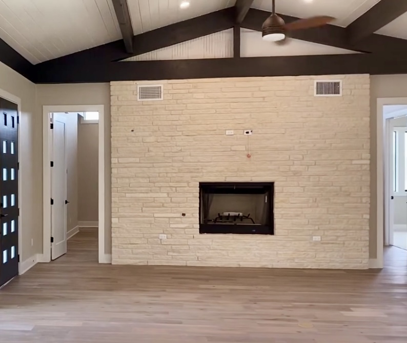 179 Shawnee Trail Dripping Springs, TX 78620 - Photo 4 of 17 a view of an empty room with wooden floor and a fireplace