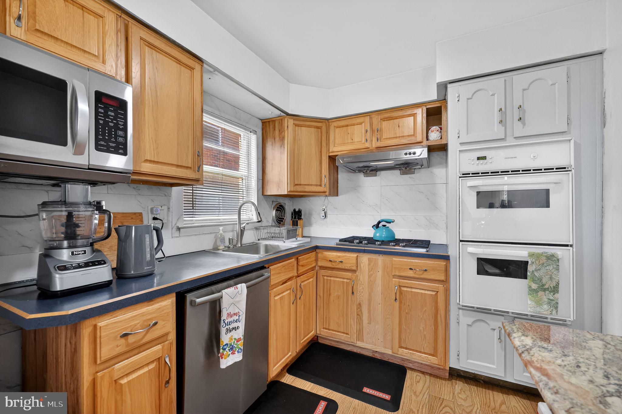 a kitchen with stainless steel appliances granite countertop a sink a stove and cabinets