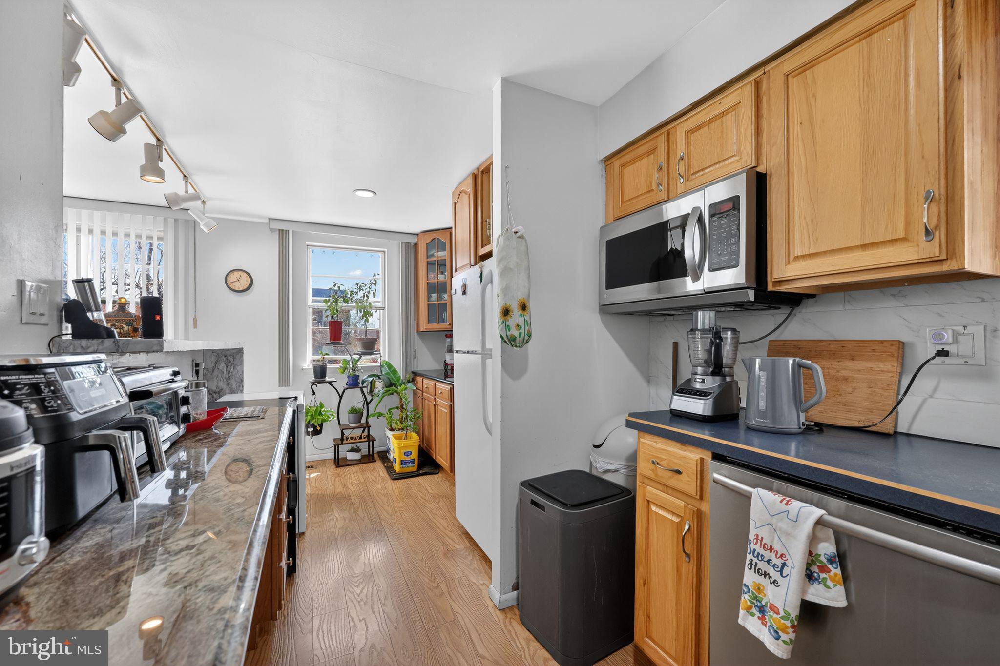 9766 Hilspach Street Philadelphia, PA 19115 - Photo 7 of 30 a kitchen with stainless steel appliances granite countertop a stove top oven a sink dishwasher and cabinets with wooden floor
