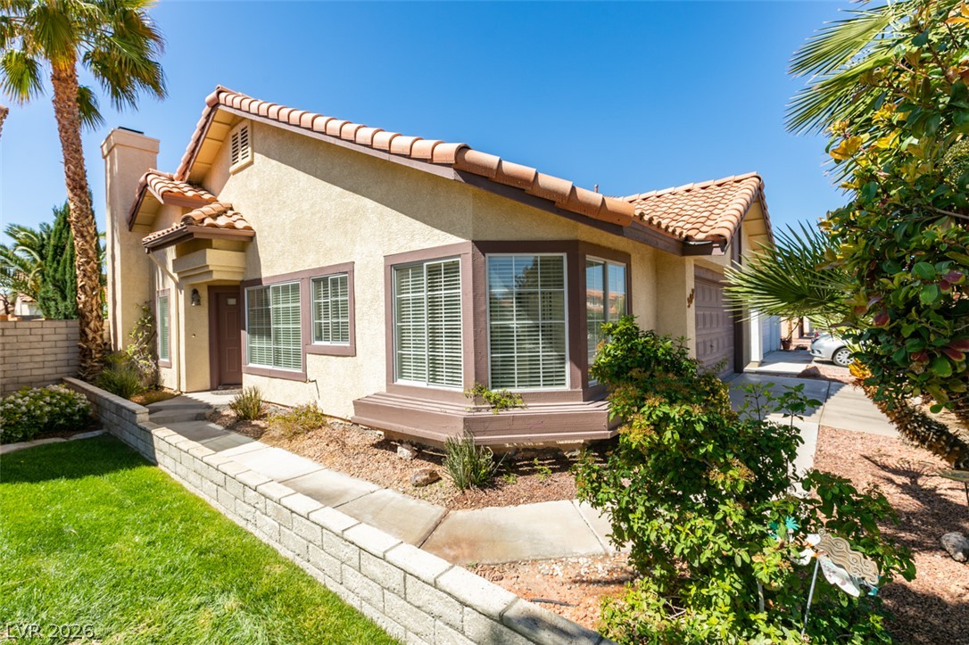 307 Cavalla Street Henderson, NV 89074 - Photo 4 of 44 A terracotta-tiled roof crowns this appealing stucco home, featuring a manicured front lawn and a bay window.