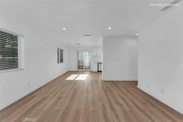 a view of empty room with wooden floor and windows