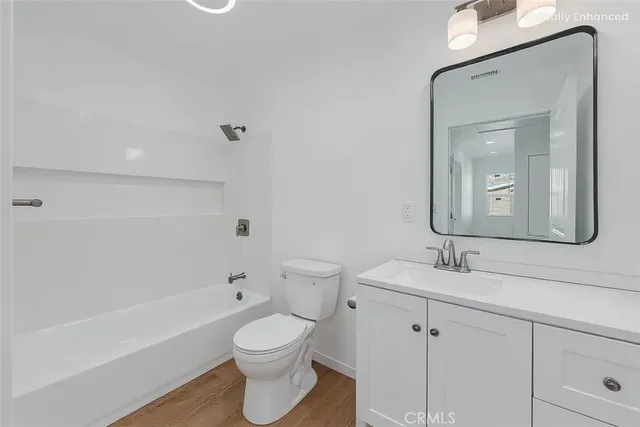 a bathroom with a toilet a sink a tub and mirror