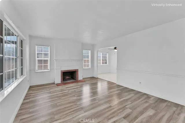wooden floor fireplace and windows in an empty room