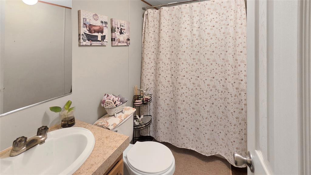 14628 Fm Road Scurry, TX 75158 - Photo 8 of 14 a white toilet sitting next to a bathroom sink