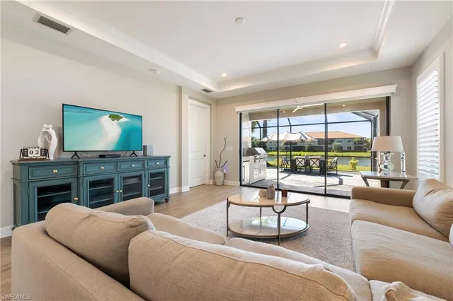 a living room with furniture a flat screen tv and a large window