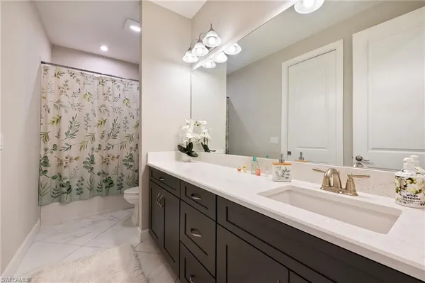 a bathroom with a double vanity sink mirror and shower