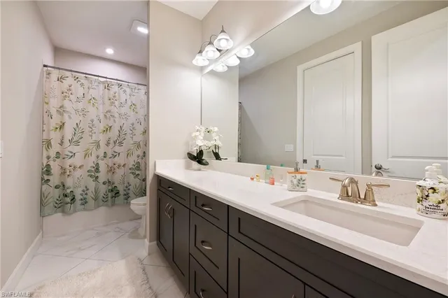 a bathroom with a double vanity sink mirror and shower