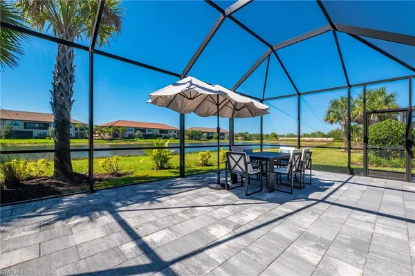 a view of a patio with a table and chairs under an umbrella