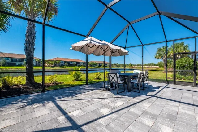 a view of a patio with a table and chairs under an umbrella
