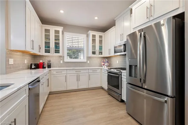 a kitchen with granite countertop stainless steel appliances a refrigerator sink and cabinets