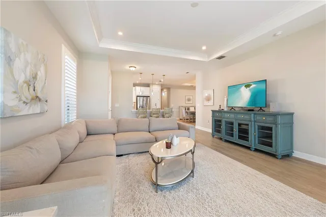 a living room with furniture a flat screen tv and a floor to ceiling window