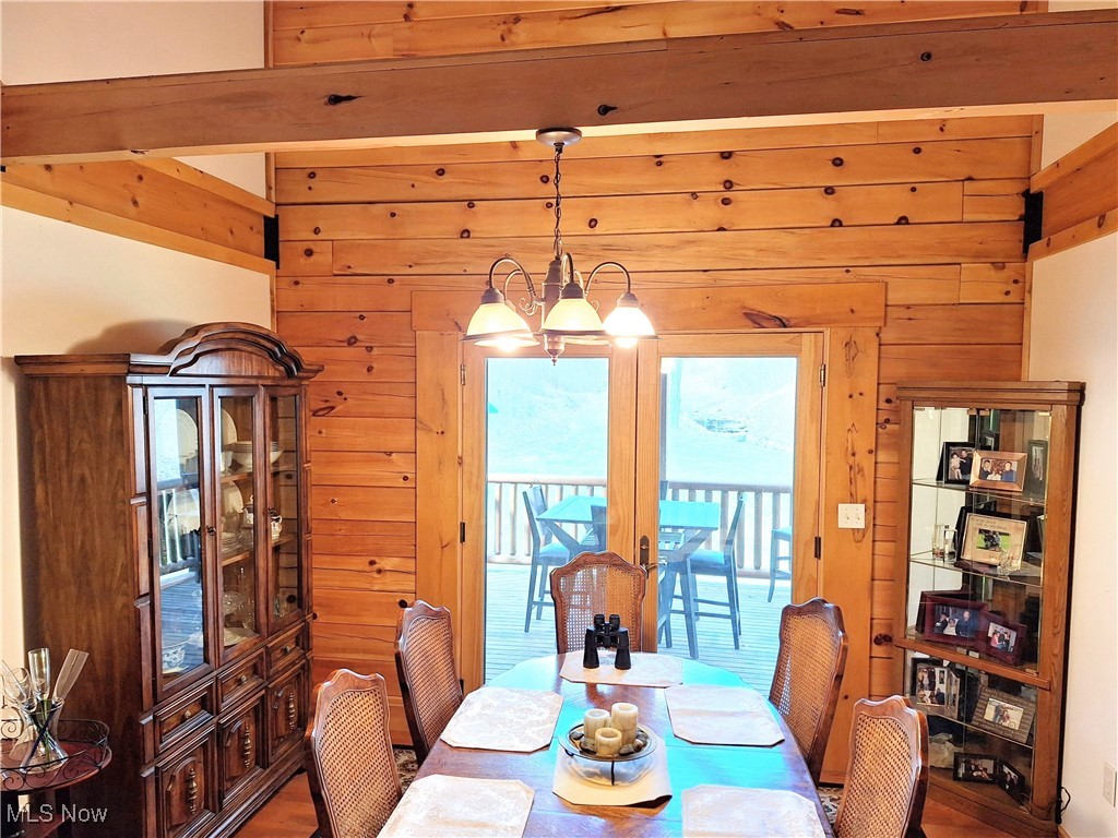 587 North Fork Road Wheeling, WV 26003 - Photo 16 of 35 Dining space with french doors, wooden walls, and an inviting chandelier
