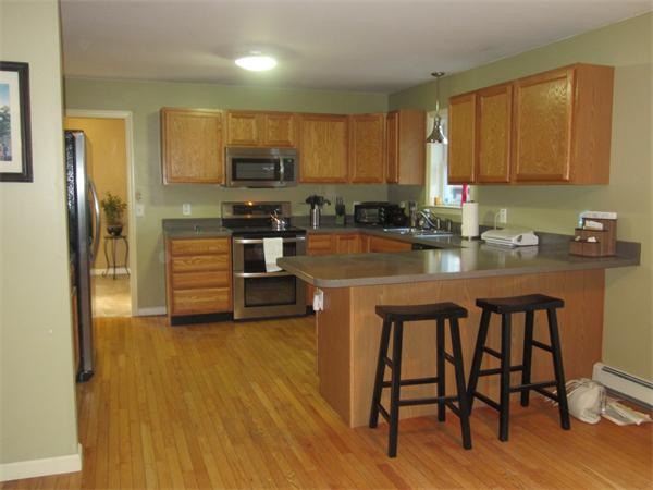 237 Kelly Road Northbridge, MA 01534 - Photo 8 of 22 a kitchen with stainless steel appliances a sink a stove a refrigerator cabinets and dining table