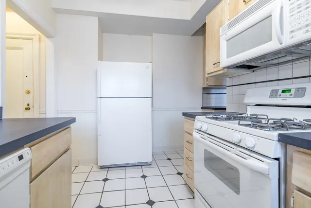 a kitchen with a stove top oven and cabinets