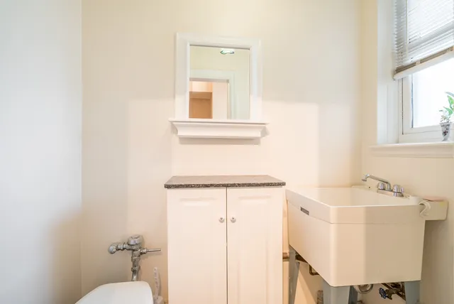 a bathroom with a sink toilet and mirror
