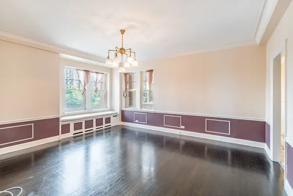 a view of a livingroom with wooden floor and large windows