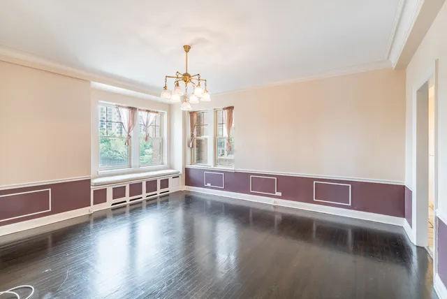 a view of a livingroom with wooden floor and large windows