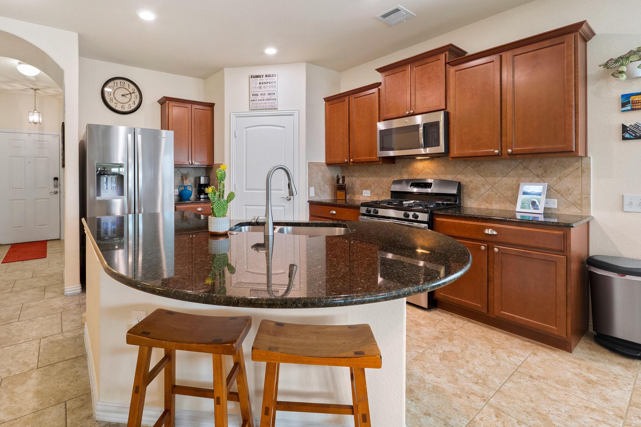 6905 Vail Ridge Street Austin, TX 78744 - Photo 7 of 39 Kitchen featuring granite countertops, stainless steel appliances, wood cabinetry, tile flooring, and recessed lighting