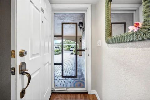 a view of a hallway with wooden floor and a living room