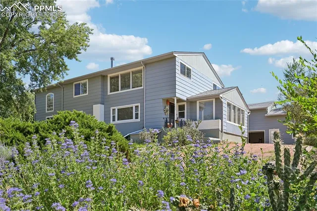 a front view of a house with a yard and trees