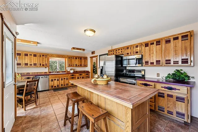 a kitchen with stainless steel appliances granite countertop a table and chairs