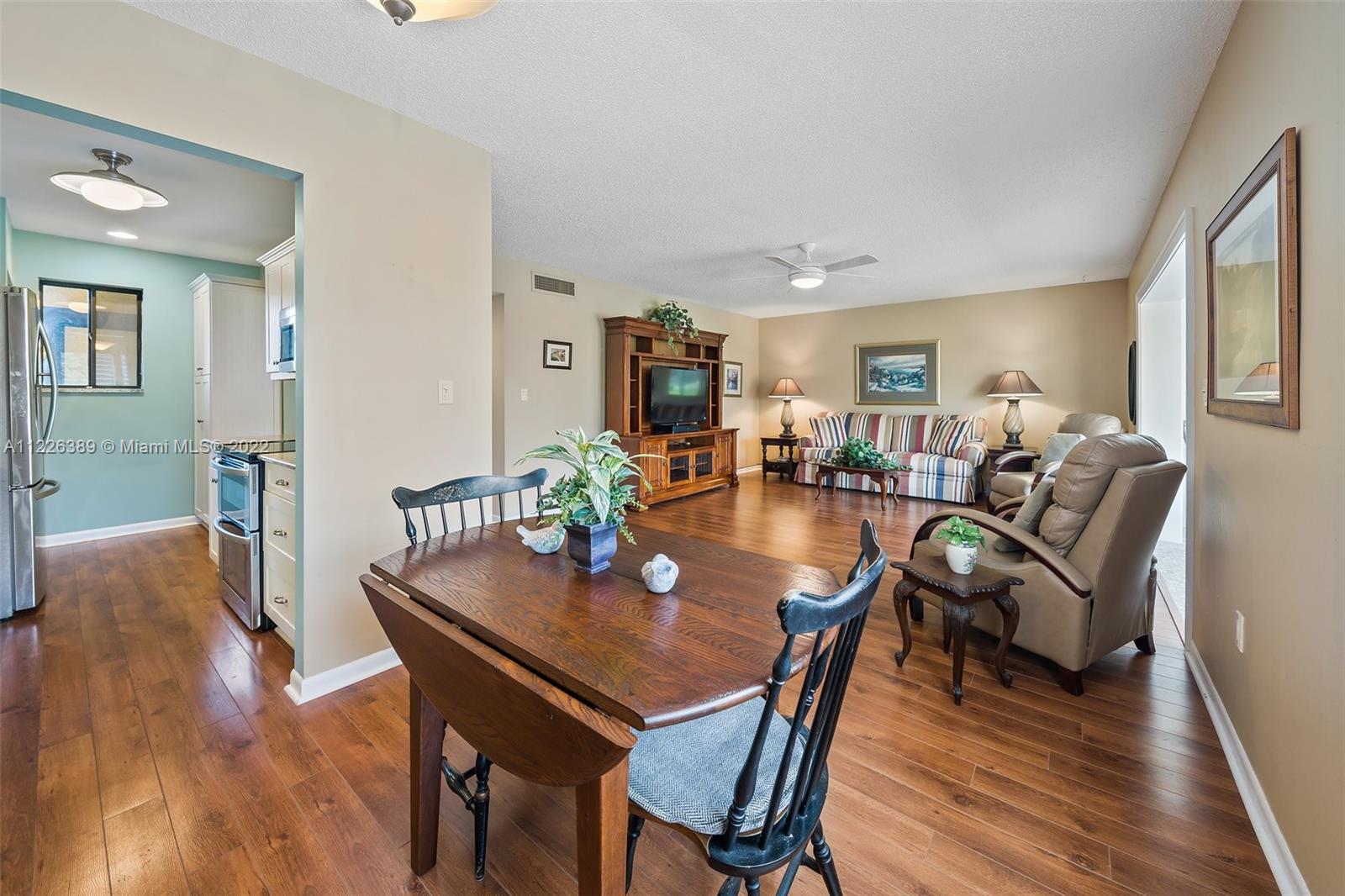 5335 Southeast Miles Grant Road, Unit 107 Stuart, FL 34997 - Photo 12 of 44 a view of a dining room with furniture and wooden floor