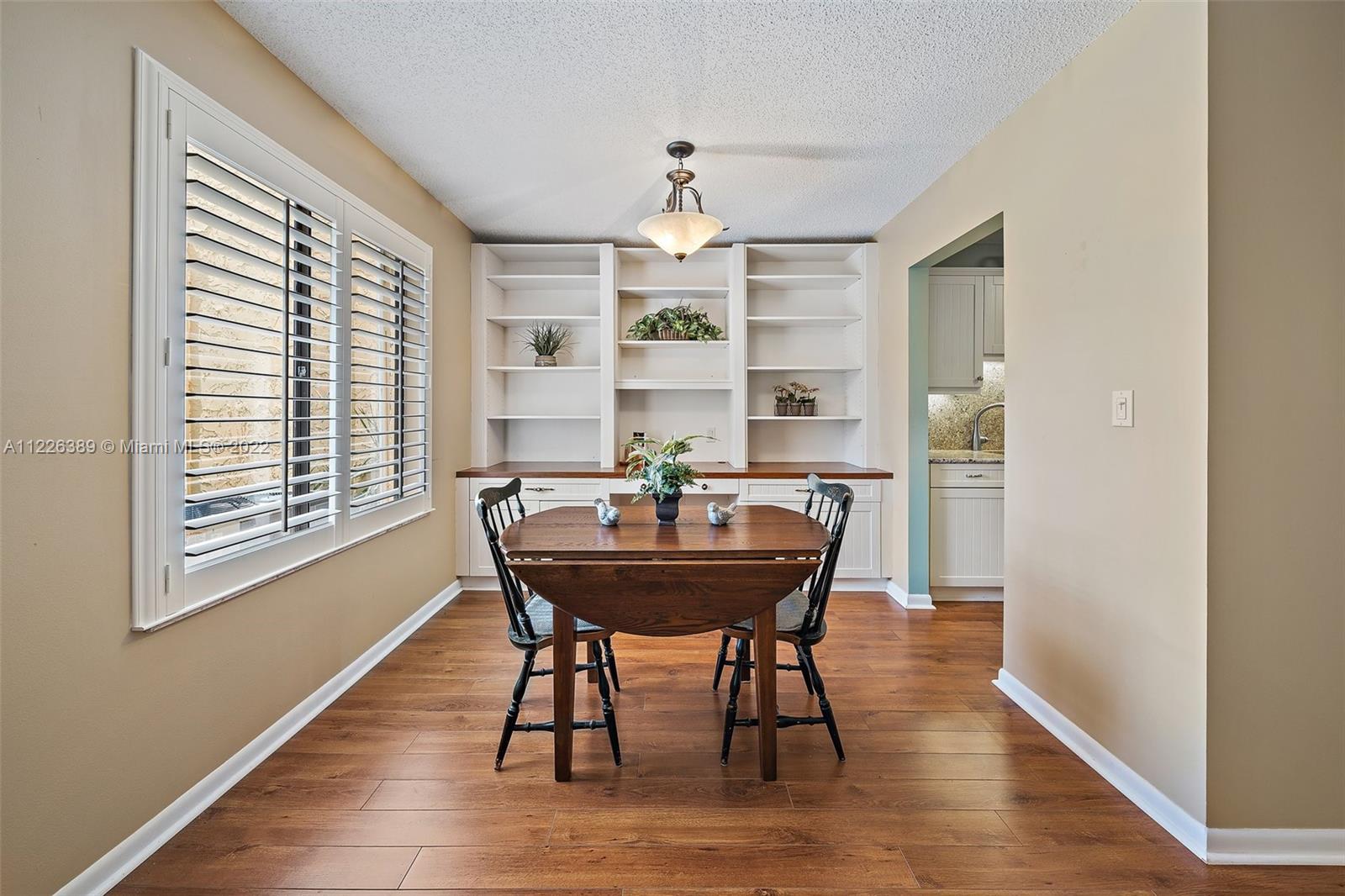 5335 Southeast Miles Grant Road, Unit 107 Stuart, FL 34997 - Photo 14 of 44 a view of a dining room with furniture window and wooden floor