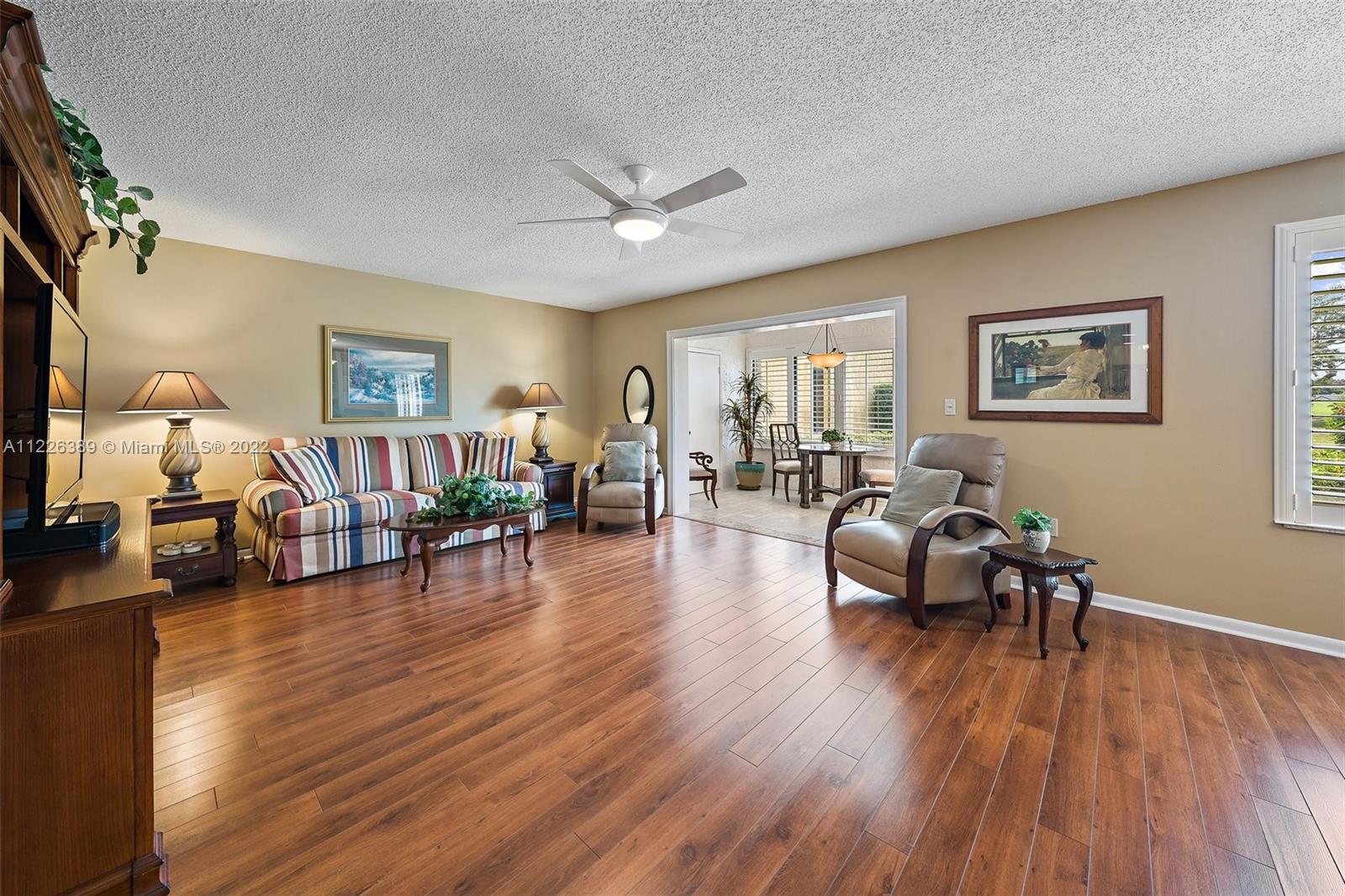 5335 Southeast Miles Grant Road, Unit 107 Stuart, FL 34997 - Photo 15 of 44 a living room with furniture and a wooden floor