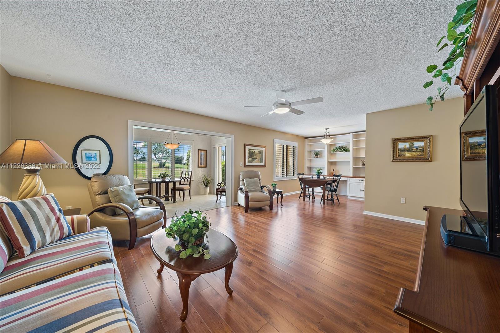 5335 Southeast Miles Grant Road, Unit 107 Stuart, FL 34997 - Photo 16 of 44 a living room with furniture and a wooden floor