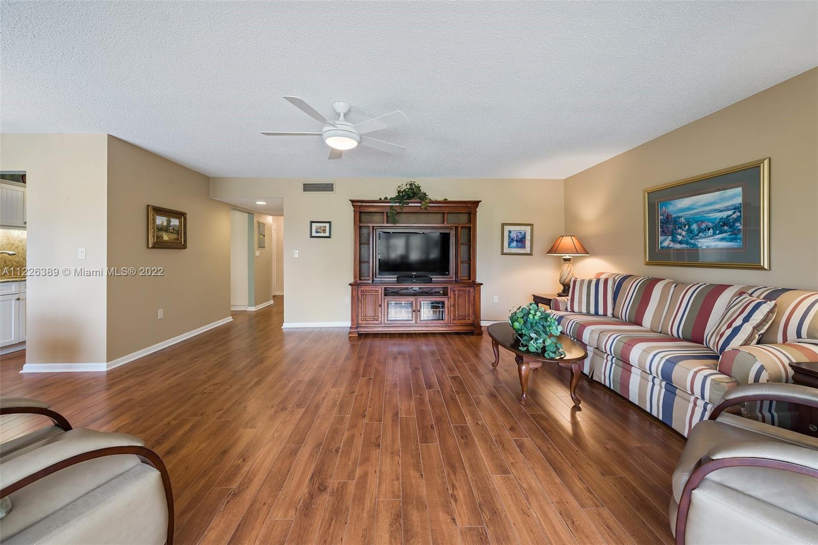 5335 Southeast Miles Grant Road, Unit 107 Stuart, FL 34997 - Photo 17 of 44 a living room with furniture and a flat screen tv
