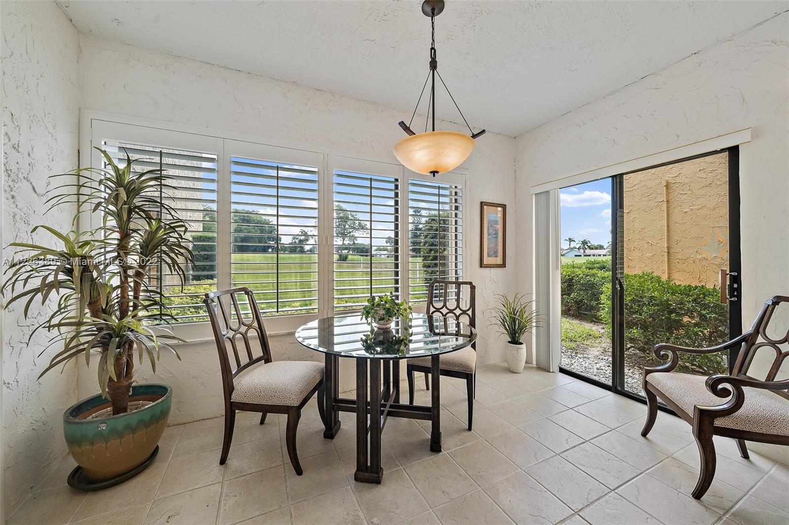 5335 Southeast Miles Grant Road, Unit 107 Stuart, FL 34997 - Photo 18 of 44 a living room with furniture and a floor to ceiling window