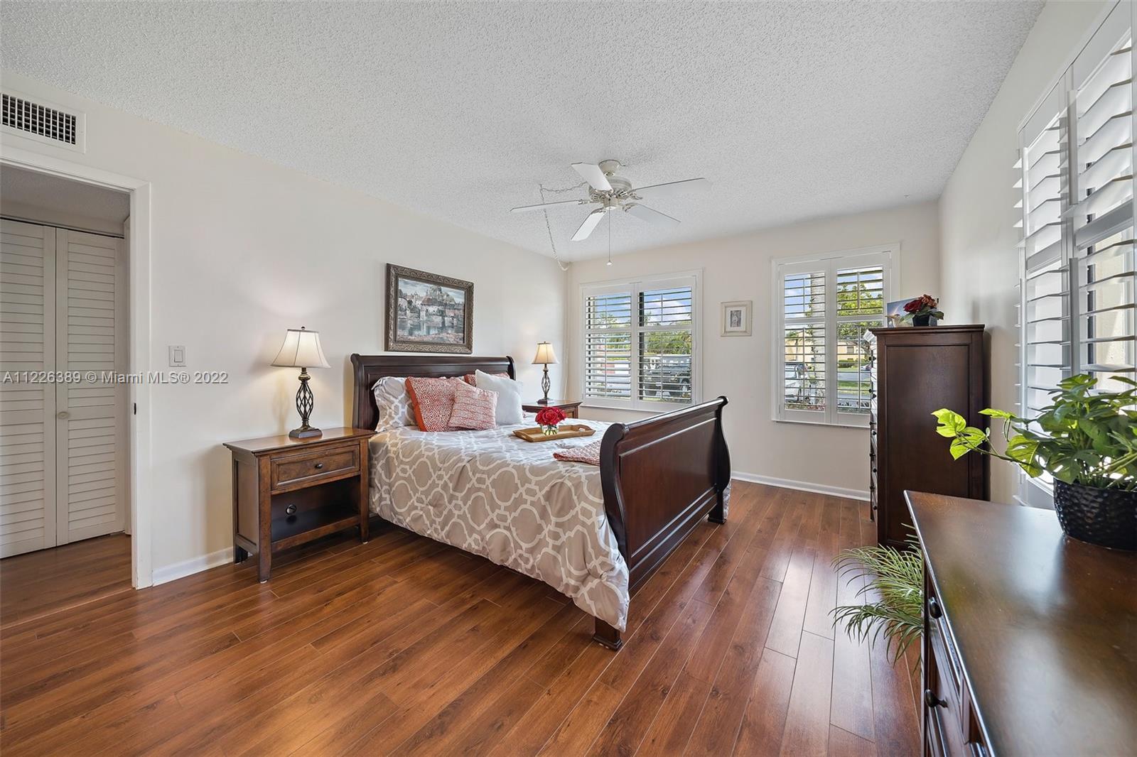 5335 Southeast Miles Grant Road, Unit 107 Stuart, FL 34997 - Photo 21 of 44 a bedroom with a bed dresser and a wooden floor
