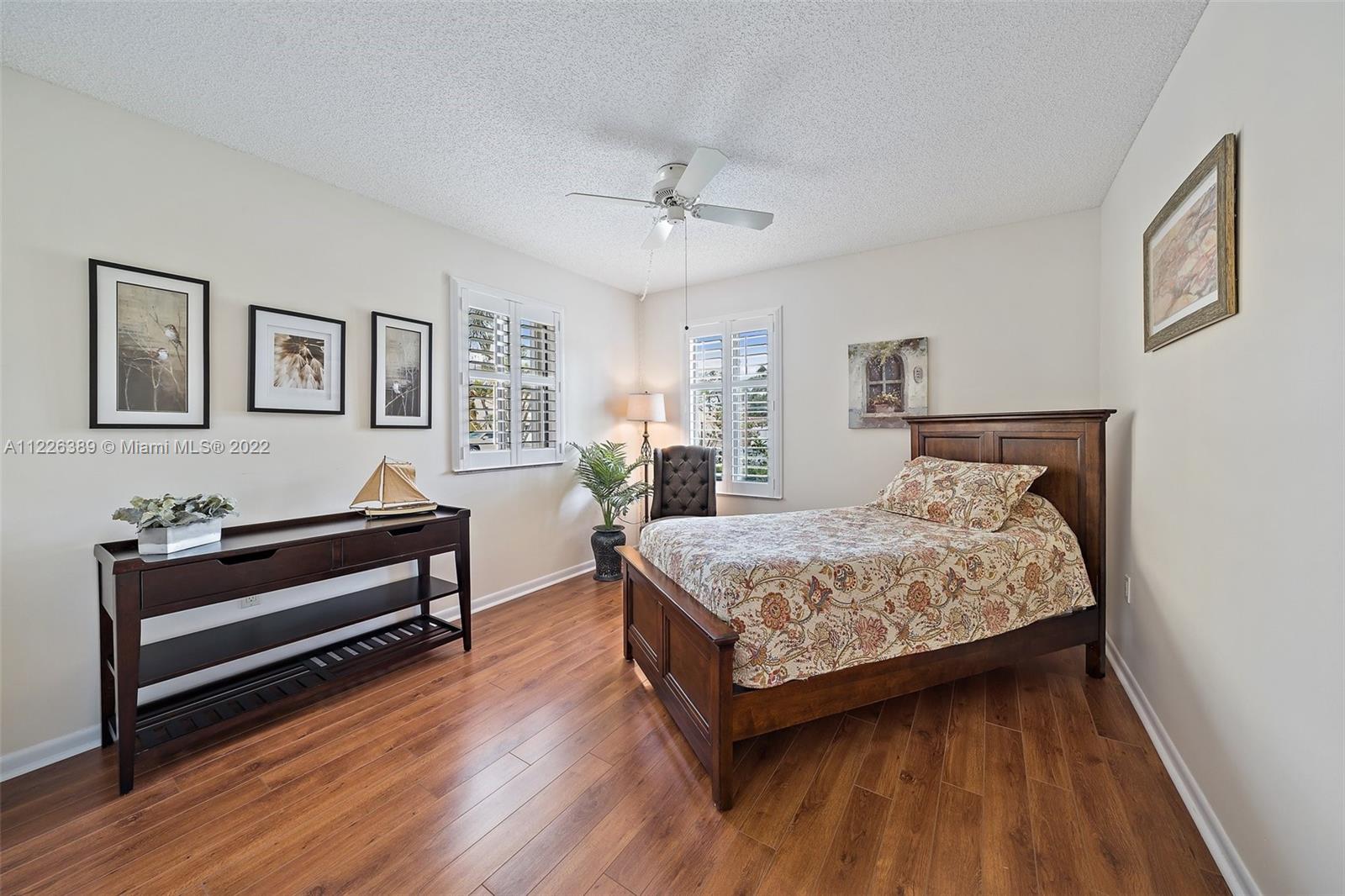 5335 Southeast Miles Grant Road, Unit 107 Stuart, FL 34997 - Photo 25 of 44 a bedroom with a bed and a chandelier