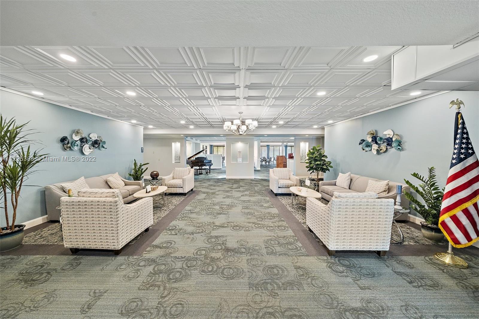5335 Southeast Miles Grant Road, Unit 107 Stuart, FL 34997 - Photo 31 of 44 a living room with furniture and a chandelier