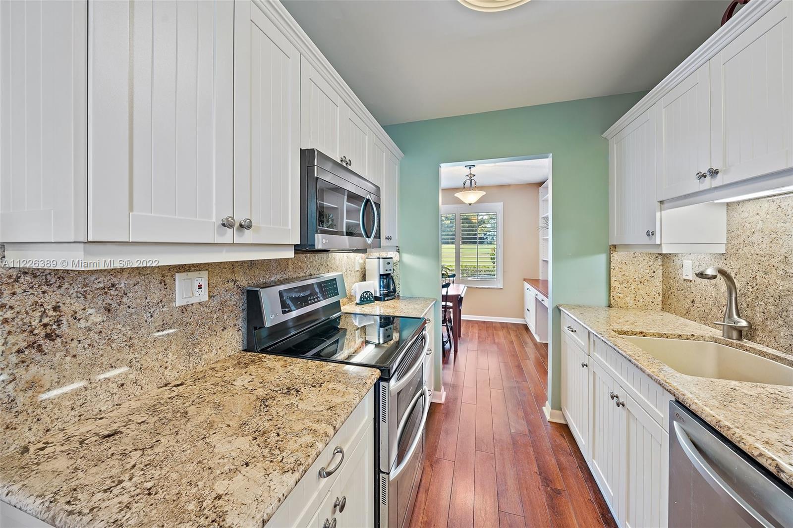5335 Southeast Miles Grant Road, Unit 107 Stuart, FL 34997 - Photo 9 of 44 a kitchen with stainless steel appliances granite countertop a sink stove and refrigerator