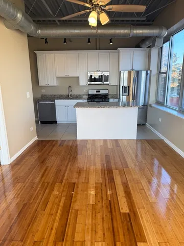 a view of kitchen with wooden floor and electronic appliances